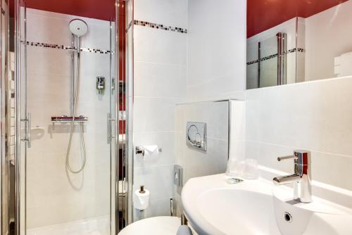 a bathroom with a shower and a sink and a toilet at Mercure Paris Bastille Marais in Paris