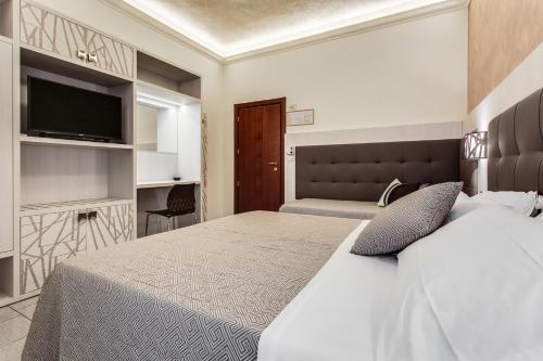 a hotel room with two beds and a television at Hotel Dolcevita in Cesenatico