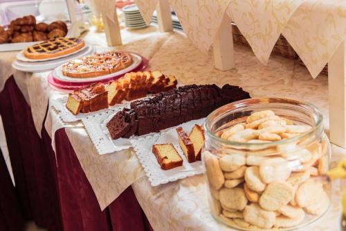 a table topped with different types of cakes and pastries at Hotel Dolcevita in Cesenatico