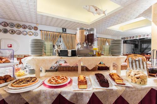 a table with many different types of cakes and pastries at Hotel Dolcevita in Cesenatico