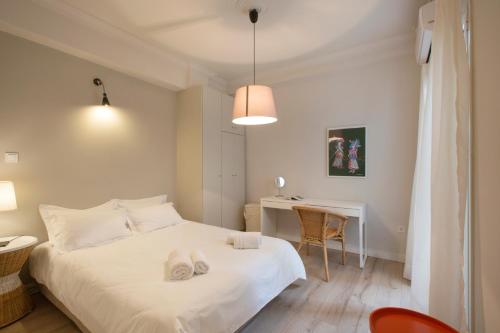 a bedroom with a white bed and a desk at Apollo Apartment @ Plaka in Athens