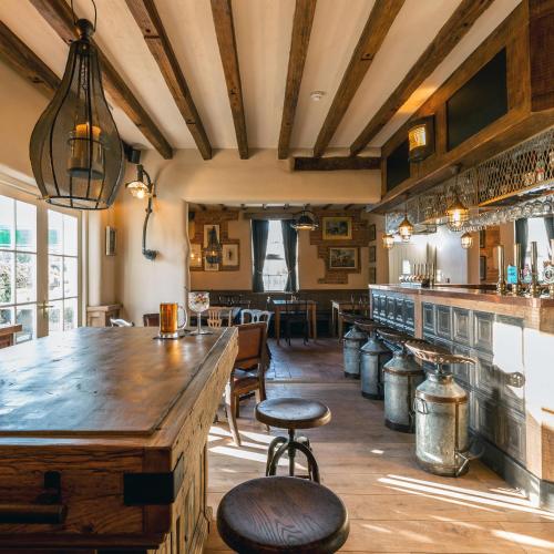 a bar with a large wooden counter in a room at The Cow Dalbury in Dalbury Lees