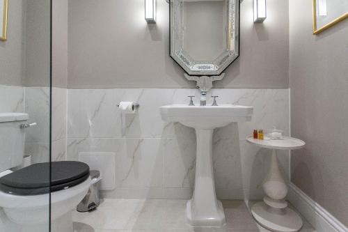 a bathroom with a toilet and a sink and a mirror at The Ormond At Tetbury in Tetbury