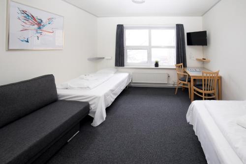 a hotel room with two beds and a couch at Vildbjerg Sports Hotel & Kulturcenter in Vildbjerg