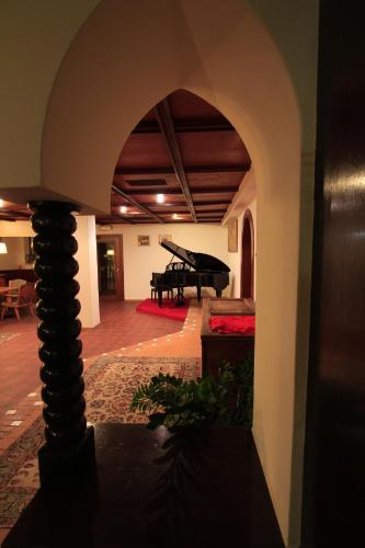 an archway in a room with a piano in the background at Hotel Regina Delle Dolomiti in Panchia