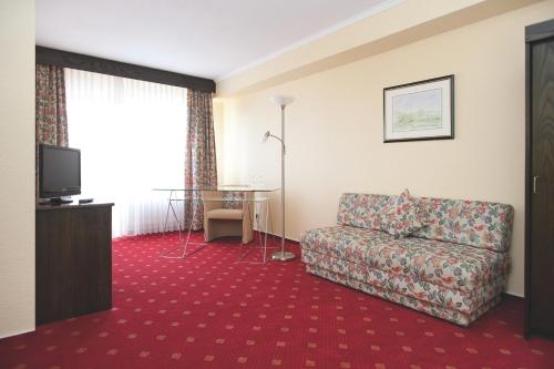 a living room with a couch and a table at Hotel Klinkner in Emmelshausen