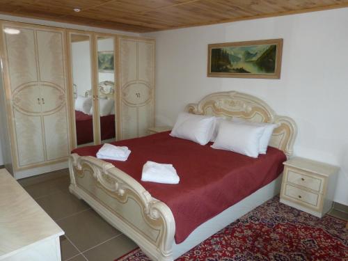 um quarto com uma cama grande com lençóis vermelhos e almofadas brancas em Sadyba Smotrytska Perlyna em Kamianets-Podilskyi