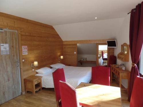 une chambre d'hôtel avec un lit, une table et des chaises dans l'établissement Hôtel les Vallois, à Vallouise