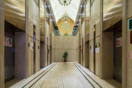 a hallway in a building with a potted plant at April Fair Duplex Apartment Guangzhou South Railway Station Ao Yuan Yue Shi Dai Branch in Guangzhou