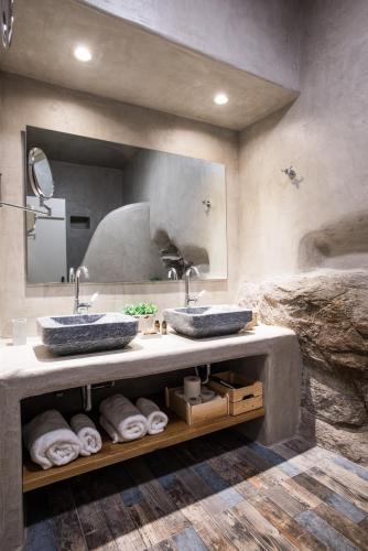 a bathroom with two sinks and a large mirror at Aletro Cottage Houses in Mikonos