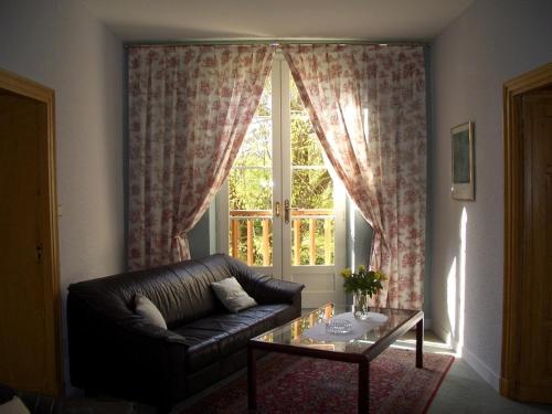 a living room with a leather couch and a glass table at Le Platane in Lafrançaise