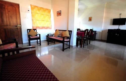 a waiting room with chairs and tables and a television at Cozy Candolim Apartment fully furnished for five adults in Candolim