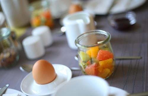 a jar of fruit and an egg on a table at Ernst Clüsserath Weingut & Weinhotelchen in Trittenheim