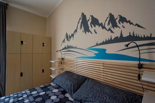a bedroom with a bed with a mountain mural on the wall at Snowake House in Castel di Sangro