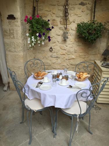 a table with a white tablecloth and chairs with food on it at Un Patio en Luberon in Ansouis