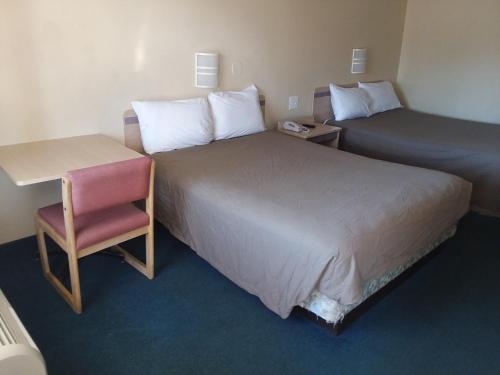 a hotel room with two beds and a desk and a chair at Knights Inn Burlington NC in Burlington