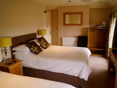 a hotel room with two beds and two lamps at The Arun View Inn in Littlehampton