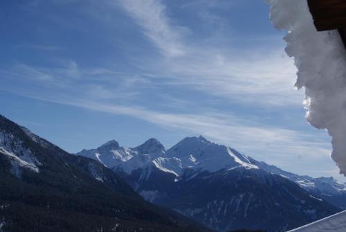 a view of a mountain range with snow capped mountains at Chalet Lenzerheide-Sporz in Lenzerheide