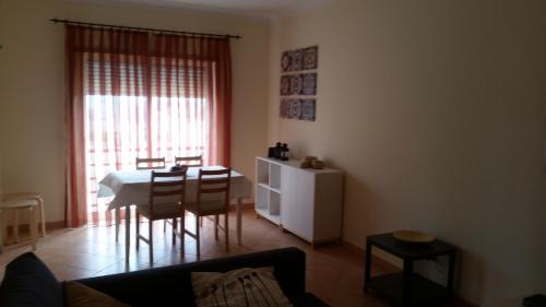 a living room with a table and chairs and a window at Cabanas1 in Cabanas de Tavira