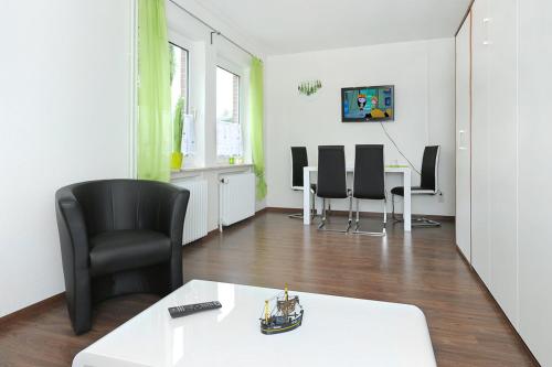 ノイハルリンガージールにあるHaus Hafenromantikのリビングルーム(テーブル、黒い椅子付)