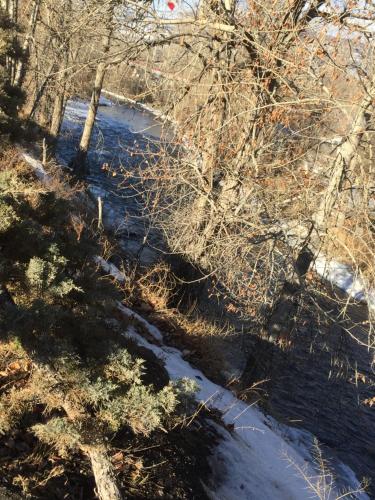 a river with snow on the ground next to trees at Riverside Motel Cache Creek in Cache Creek