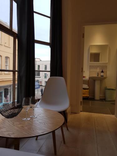 two wine glasses sitting on a table in front of a window at The Antidote in Ilfracombe