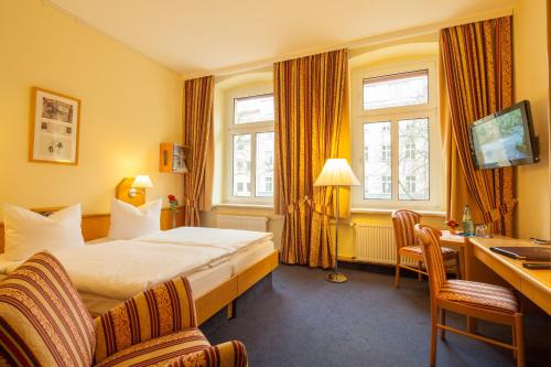 Habitación de hotel con cama y escritorio en Hotel Kastanienhof, en Berlín