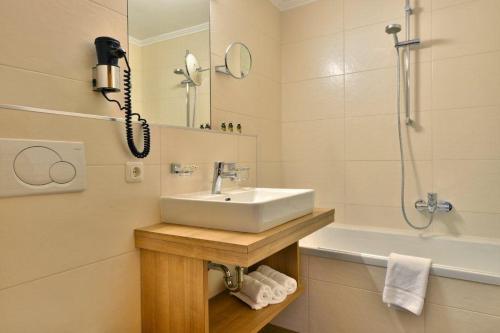 La salle de bains est pourvue d'un lavabo, d'une douche et d'un téléphone. dans l'établissement Gasthof und Hotel Rieder GmbH, à Jenbach