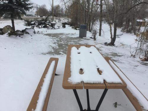 a wooden bench covered in snow in a park at Riverside Motel Cache Creek in Cache Creek