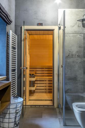 a bathroom with a shower with a wooden door at N°75- Na Uboczu in Krynica Zdrój