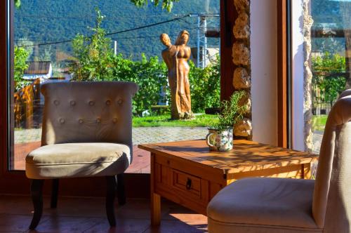 a room with a chair and a table and a statue at GRANÁRIUM in Jablonov nad Turnou