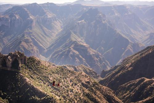 a group of people on a zip line in the mountains at Hotel Barrancas del Cobre a Balderrama Hotel Collection in Areponapuchi
