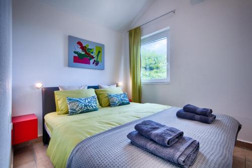 a bedroom with a bed with towels on it at Seafront Suites Maja in Vis