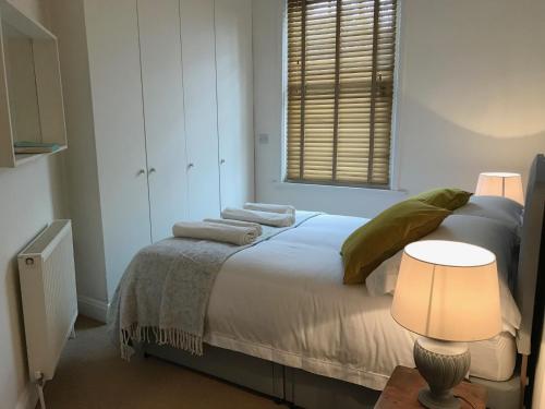 a bedroom with a bed and a lamp and a window at Flat 4, York Terrace in Norwich