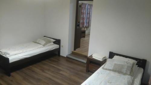 two beds sitting in a room with a mirror at Wanta z pyszną karczmą in Bukowina Tatrzańska