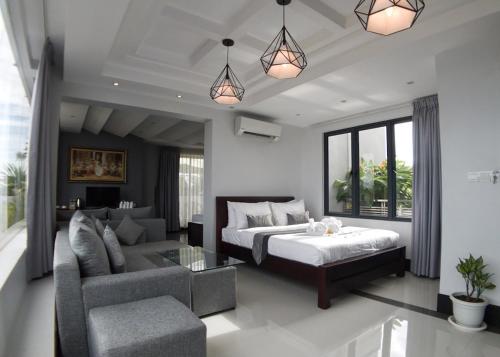 a bedroom with a bed and a living room at Hotel Five.S in Kampot