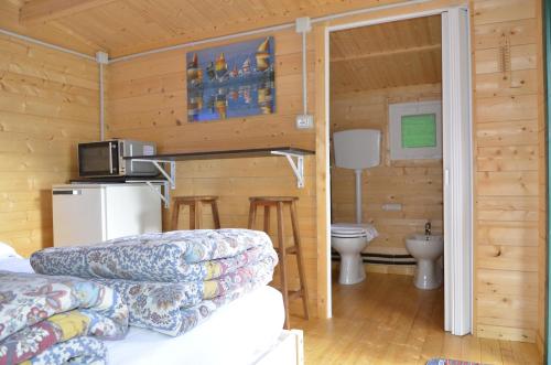 una baita di tronchi con cucina e servizi igienici di Camping Adamello a Edolo