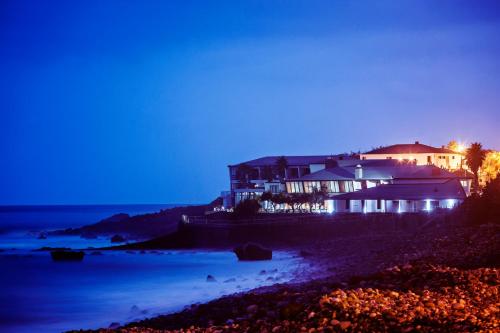 a house on the shore of a beach at night at Estalagem do Mar in São Vicente