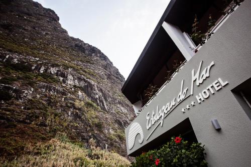 a sign for a hotel next to a cliff at Estalagem do Mar in São Vicente