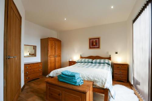 a bedroom with a bed and two dressers at Crackin View Holiday cottage in Hexham