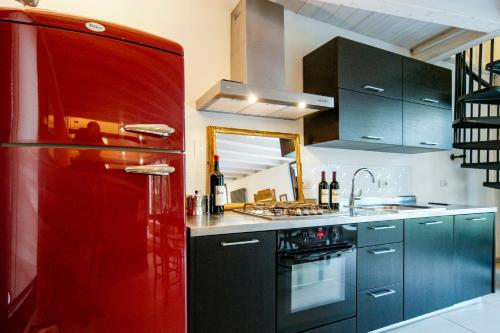 a kitchen with a red refrigerator and black cabinets at Villa Betteloni Valpolicella Suites in San Pietro in Cariano