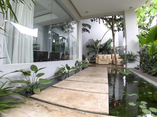 a house with a koi pond in the yard at Hotel Five.S in Kampot