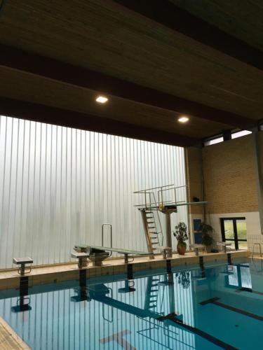 a swimming pool with a ladder in the middle of it at Idrætscenter Jammerbugt in Fjerritslev