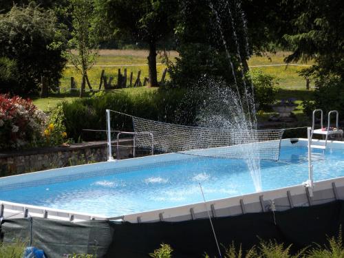 une piscine avec une fontaine à eau dans l'établissement Les Anniquins, à Ivoy-le-Pré