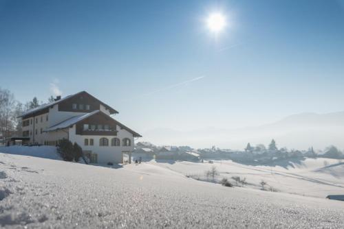 a house on top of a snow covered hill at Hotel Sonnbichl in Lam