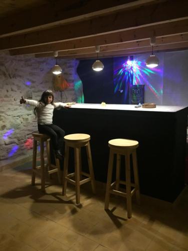 a woman sitting at a bar with two stools at Villa Jardin De l'Ocean in Aourir
