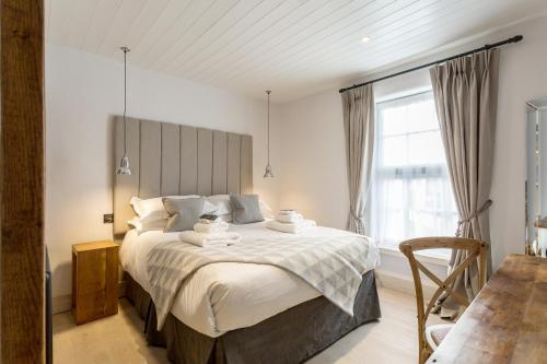 1 dormitorio con cama grande y ventana grande en The Cow Dalbury, en Dalbury Lees
