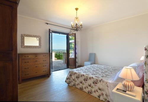 a bedroom with a bed and a dresser and a sliding glass door at Villa Santa Maria Deruta in Deruta