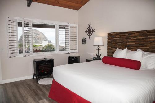 a bedroom with a large bed and a fireplace at The Landing at Morro Bay in Morro Bay