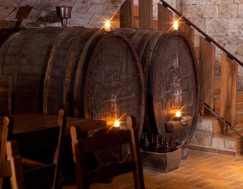 a large wooden barrel in a room with lights at Hotel Altdeutsche Weinstuben in Freyburg